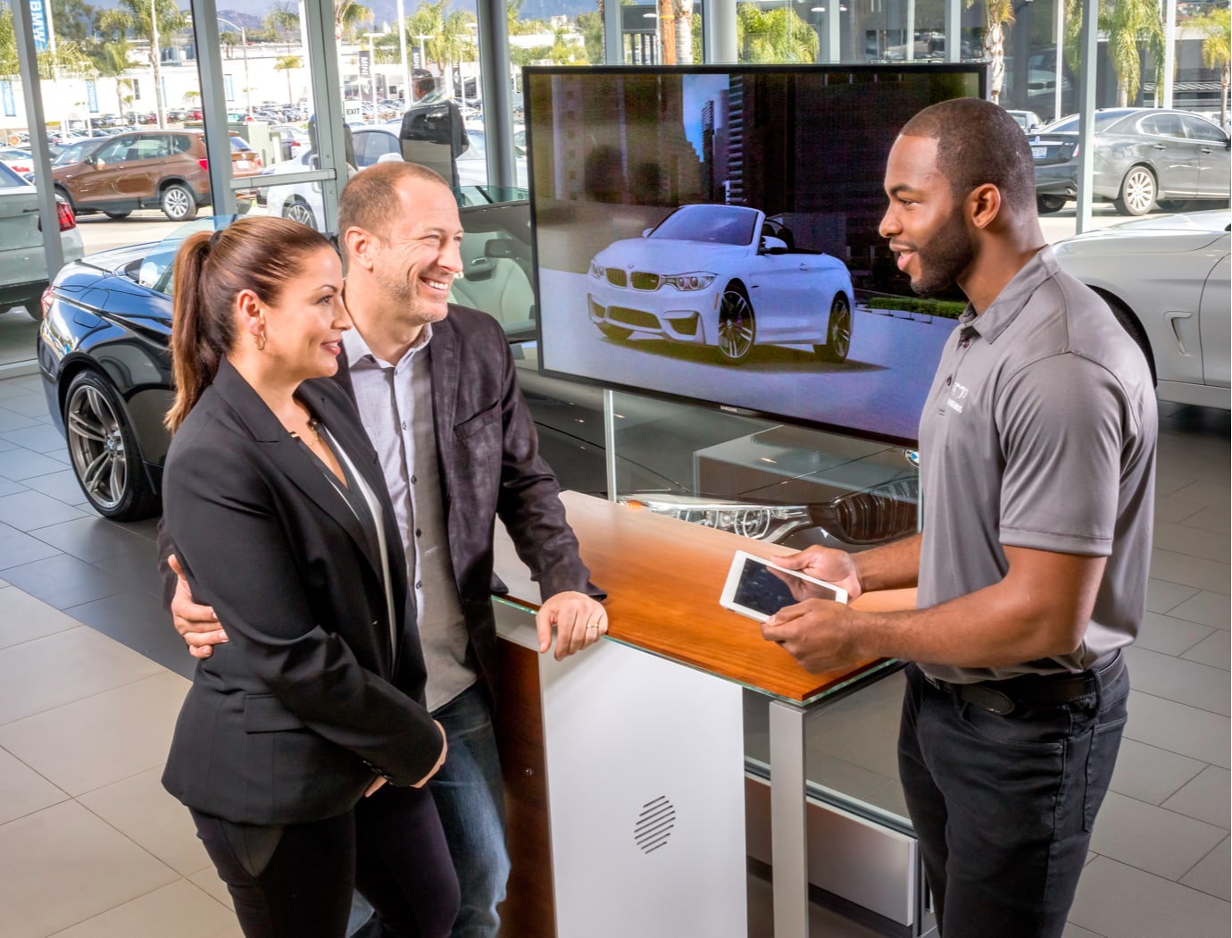 BMWHero.jpg smiling couple talks with a bmw salesman at a dealership